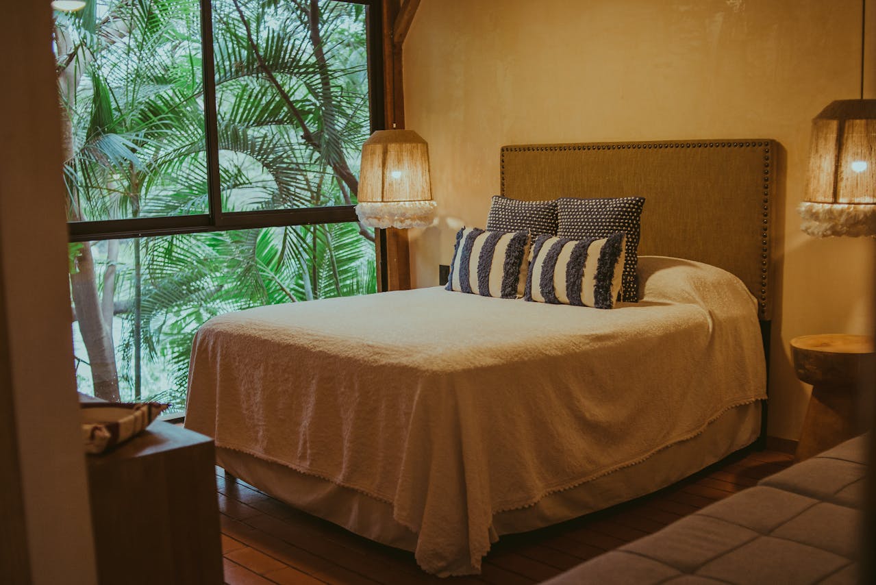bedroom with warm tones and palm trees outside