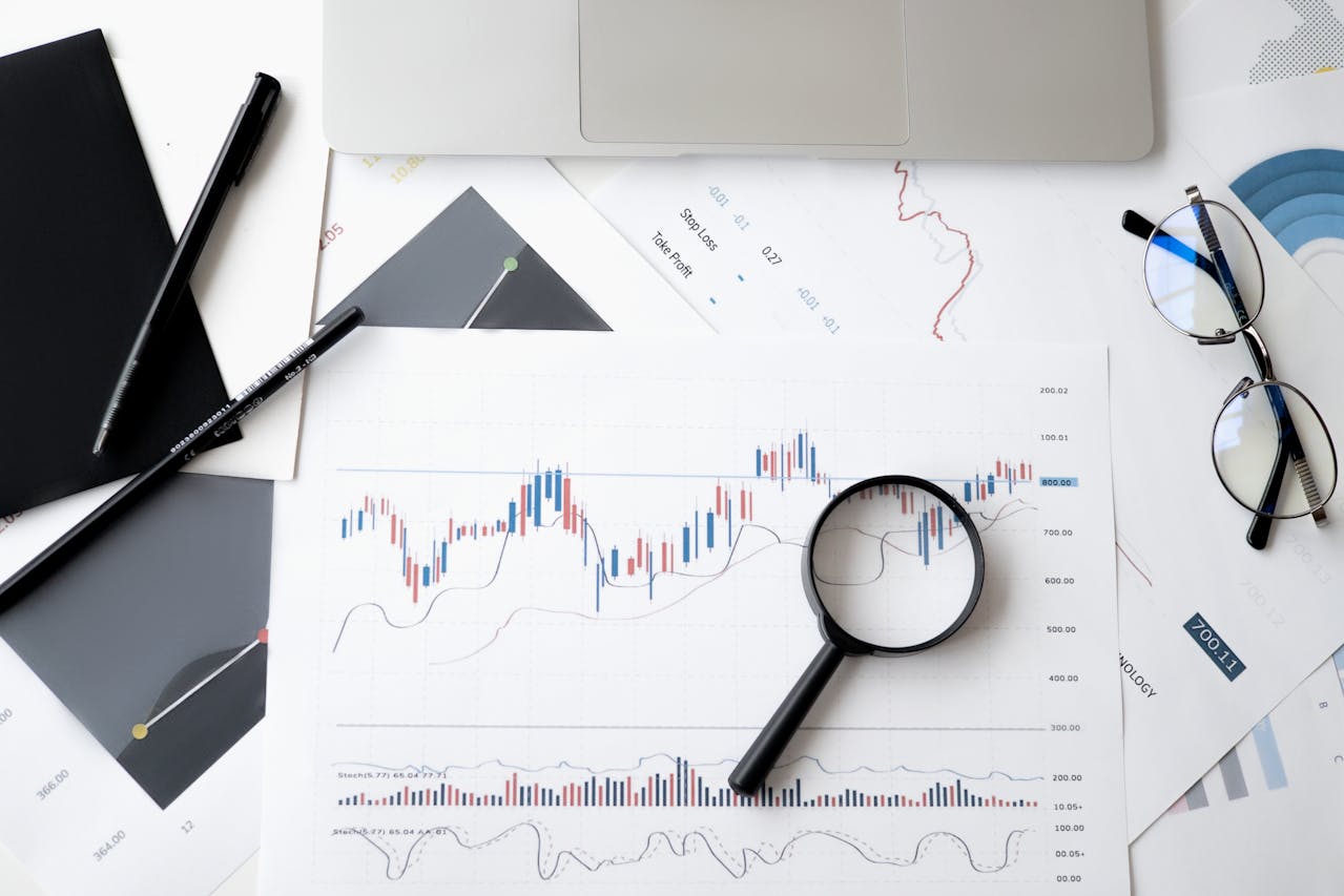 graphs on paper with magnifying glass over top